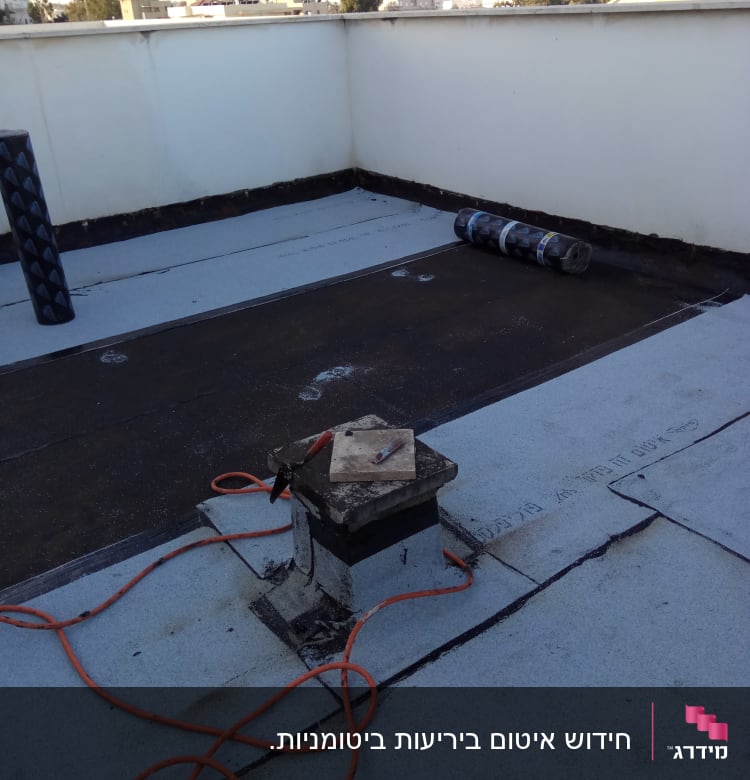 גג עם יריעות איטום, כבל חשמלי וכלי עבודה